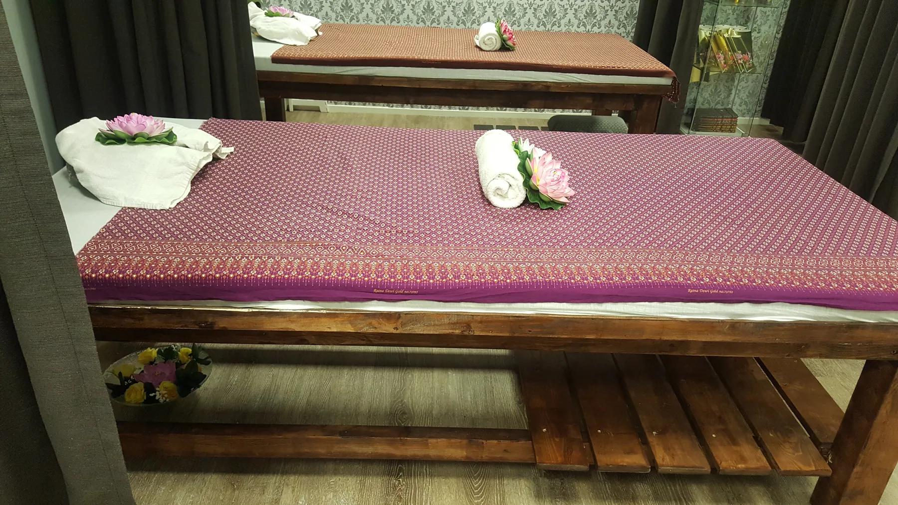 Een massagetafel in onze salon, met Thaise zijde, handdoeken en orchideeën